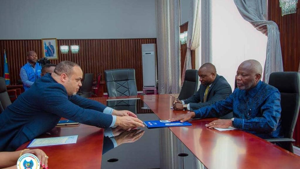 Le DG de la SNEL,  Fabrice Lusinde,  remettant un dossier au président de l'assemblée nationale,  Vital Kamerhe, lors de la réunion de ce mardi 