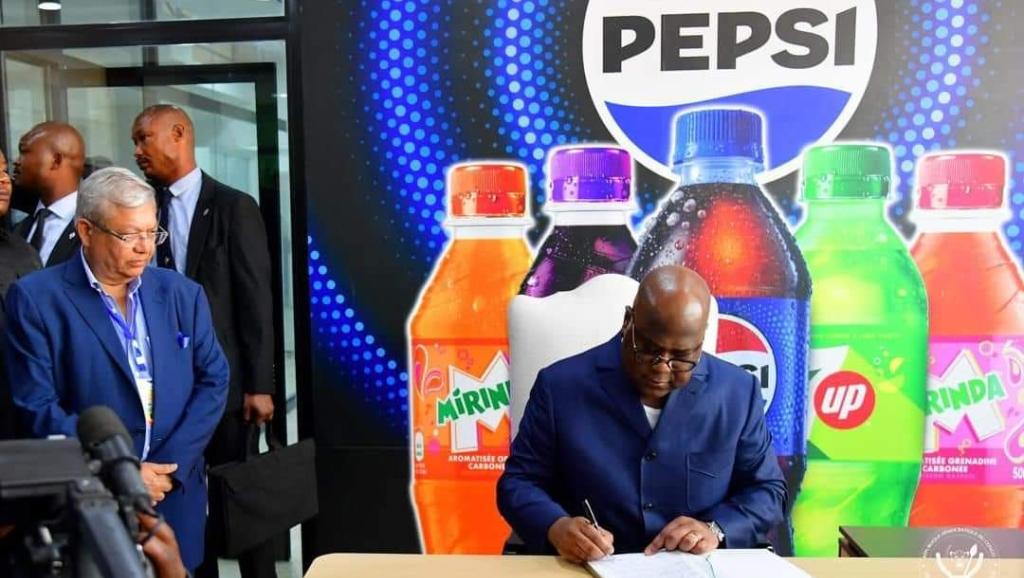 Le chef de l'État signant le livre d'or de la société PEPSI 