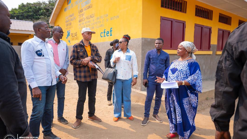 Photo de Guylain Nyembo et la délégation de CFEF au Kongo-Central, auprès d'un bâtiment  de PDL145T