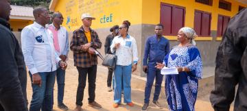 Photo de Guylain Nyembo et la délégation de CFEF au Kongo-Central, auprès d'un bâtiment  de PDL145T